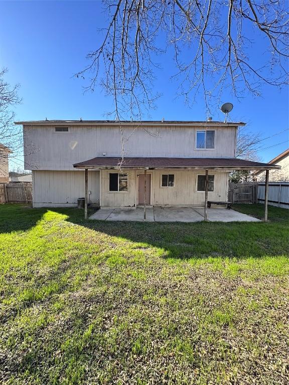 rear view of house featuring a yard and a patio