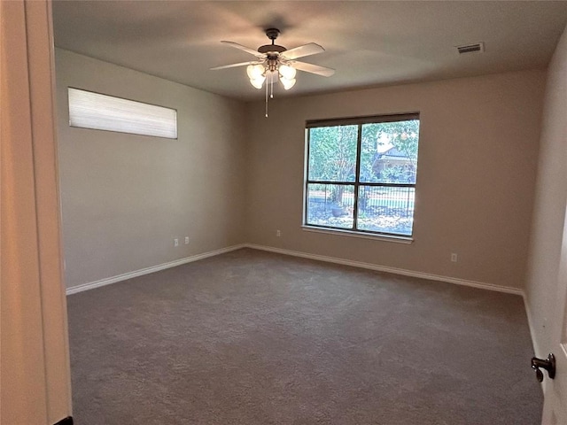 spare room with dark carpet and ceiling fan