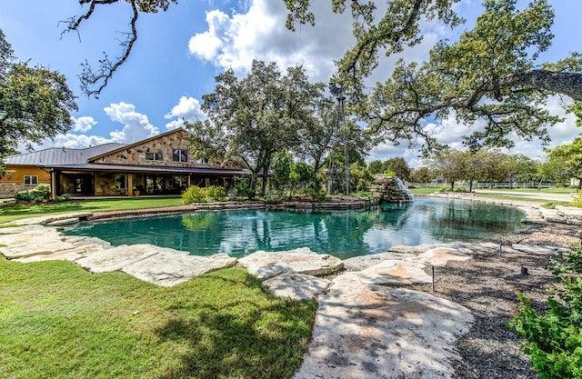 view of pool featuring a lawn