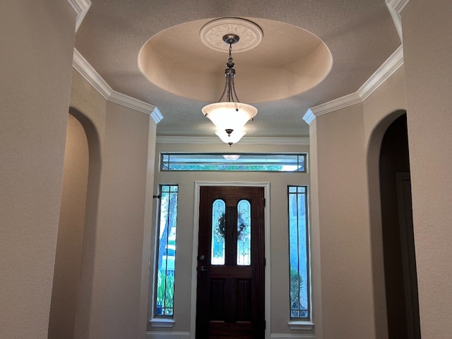 entryway featuring a raised ceiling and ornamental molding