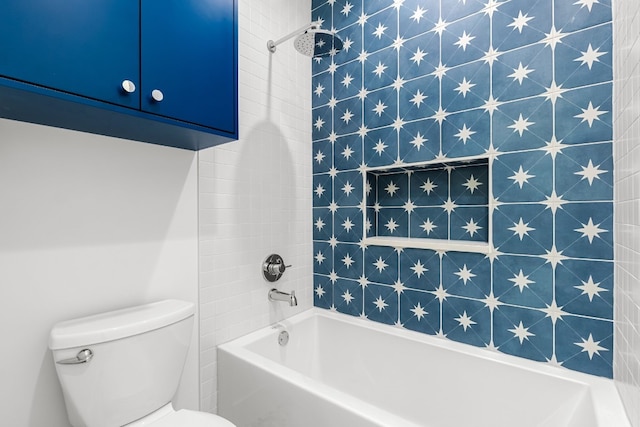 bathroom featuring toilet and tiled shower / bath