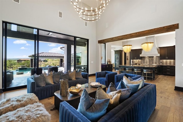 living room featuring a high ceiling, light hardwood / wood-style floors, and a notable chandelier