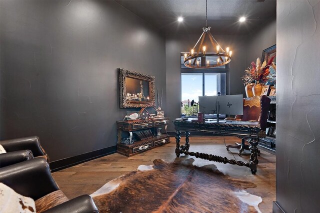 office area with hardwood / wood-style floors and an inviting chandelier