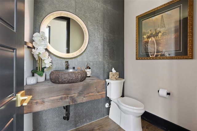 bathroom featuring backsplash, sink, wood-type flooring, and toilet