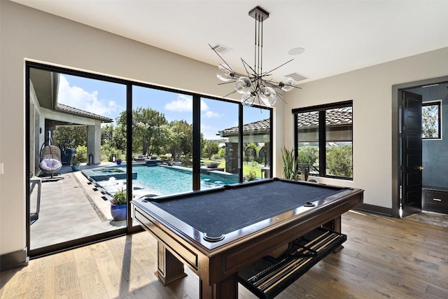 game room with hardwood / wood-style flooring, an inviting chandelier, and billiards