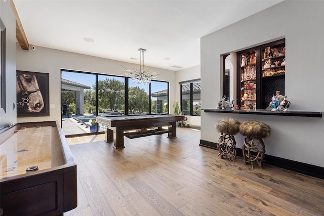 recreation room featuring beam ceiling, an inviting chandelier, billiards, and light wood-type flooring