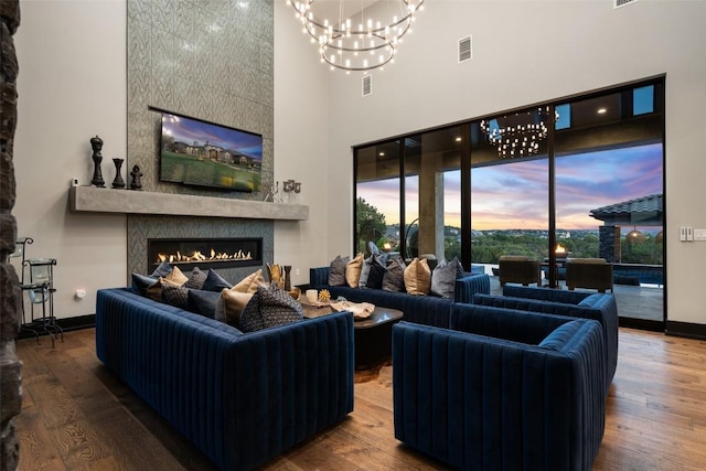 19204 Secretariat Pl, Spicewood, TX 78669 - living area with a fireplace, a towering ceiling, a chandelier, and wood finished floors
