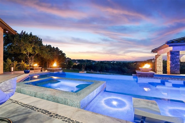 19204 Secretariat Pl, Spicewood, TX 78669 - pool at dusk with an in-ground hot tub, an outdoor pool, and a patio