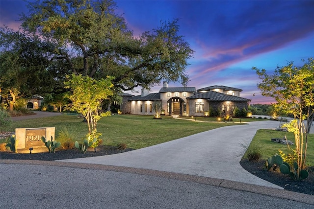 19204 Secretariat Pl, Spicewood, TX 78669 - mediterranean / spanish-style home featuring a chimney, a yard, driveway, stucco siding, and a metal roof