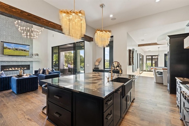 19204 Secretariat Pl, Spicewood, TX 78669 - kitchen featuring open floor plan, a chandelier, dark cabinets, and recessed lighting