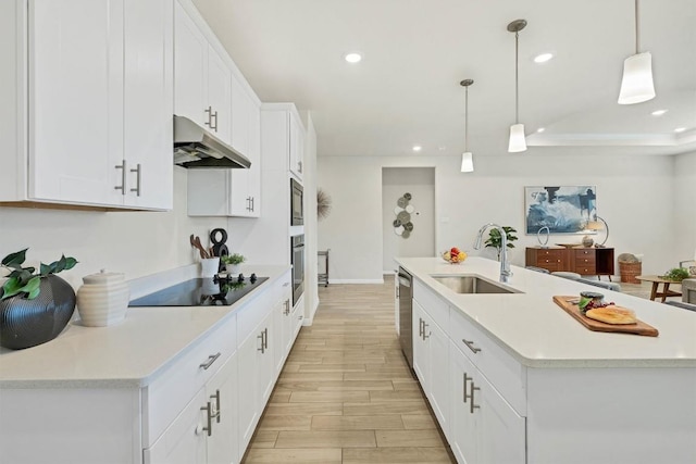 kitchen featuring sink, stainless steel appliances, decorative light fixtures, a kitchen island with sink, and white cabinets