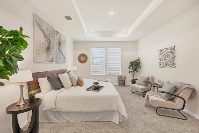 carpeted bedroom with a tray ceiling