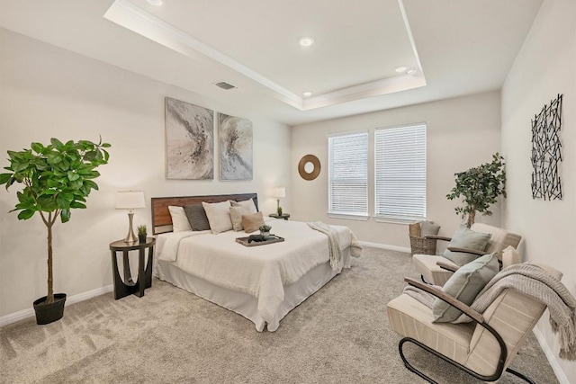 bedroom with a raised ceiling and light colored carpet