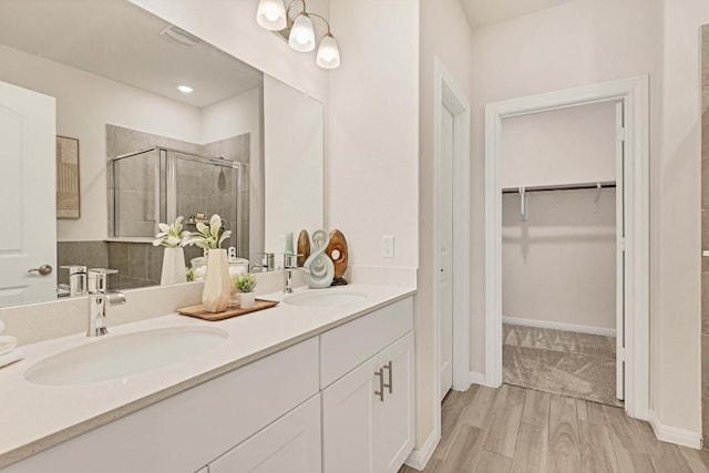 bathroom with wood-type flooring, vanity, and walk in shower