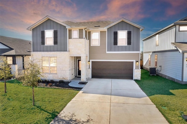 view of front of house featuring a yard, cooling unit, and a garage