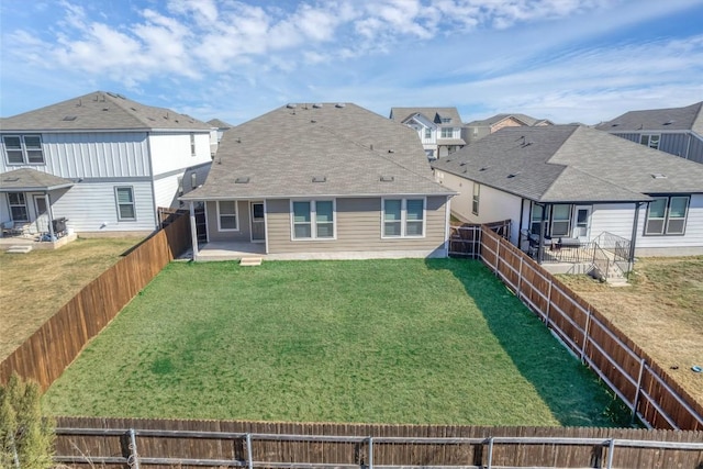 back of house with a patio area and a yard