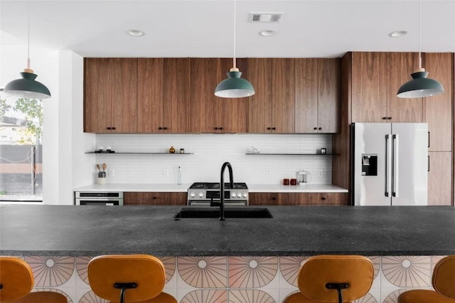 kitchen featuring pendant lighting, a breakfast bar, stainless steel appliances, and tasteful backsplash