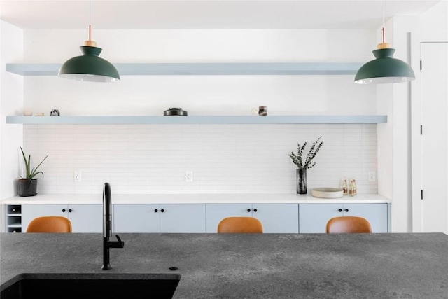 kitchen featuring pendant lighting, decorative backsplash, and sink