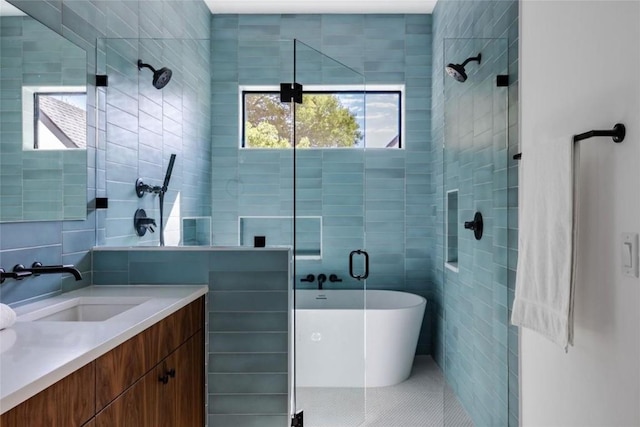 bathroom featuring tile patterned floors, vanity, tile walls, and shower with separate bathtub