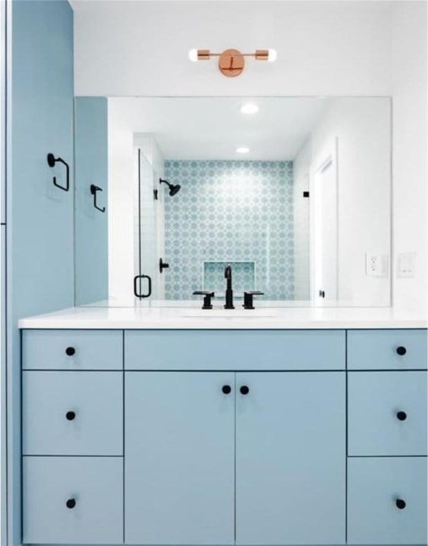 bathroom with vanity and a shower with shower door