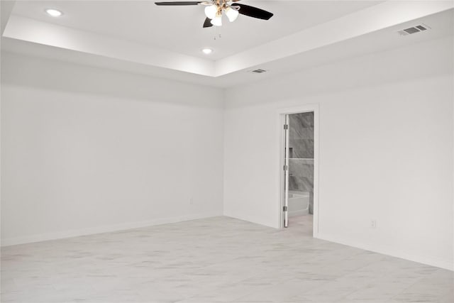 unfurnished room featuring a raised ceiling and ceiling fan