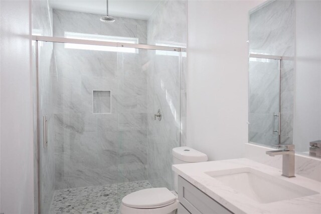 bathroom featuring vanity, an enclosed shower, and toilet