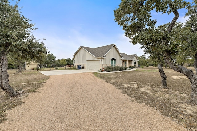 view of side of property with driveway, a garage, fence, and board and batten siding