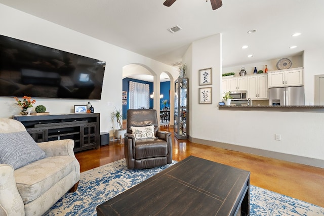 living room featuring visible vents, arched walkways, baseboards, ceiling fan, and recessed lighting