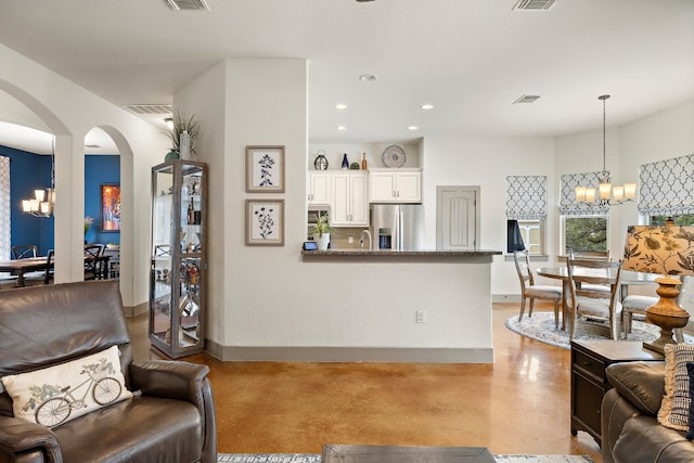 living area with arched walkways, recessed lighting, visible vents, a chandelier, and baseboards