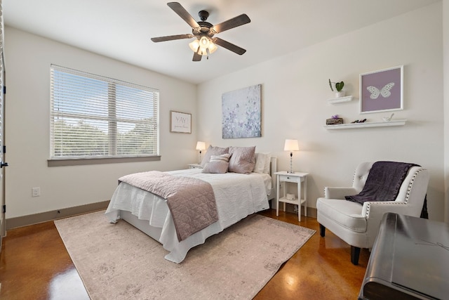 bedroom featuring a ceiling fan, baseboards, and concrete flooring