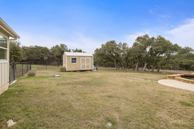 view of yard featuring an outbuilding, fence, and a storage unit