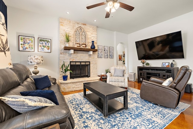 living room featuring arched walkways, a fireplace, recessed lighting, a ceiling fan, and wood finished floors