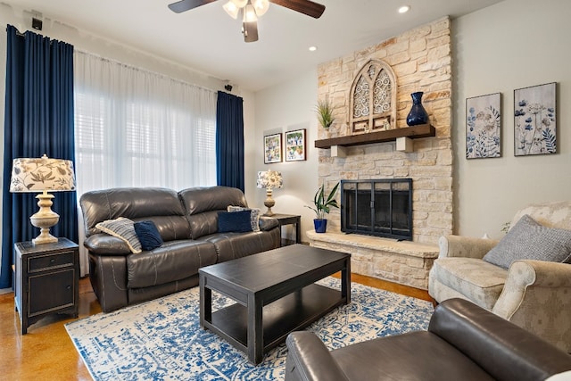 living room featuring ceiling fan and a fireplace