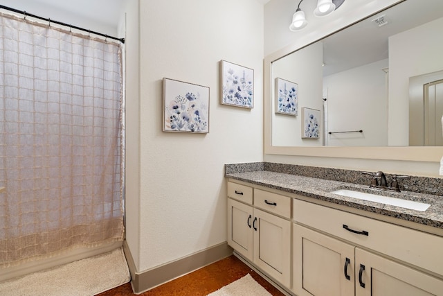 full bathroom featuring a shower with shower curtain, visible vents, vanity, and baseboards