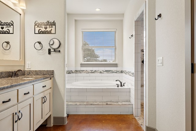 bathroom with a garden tub and vanity