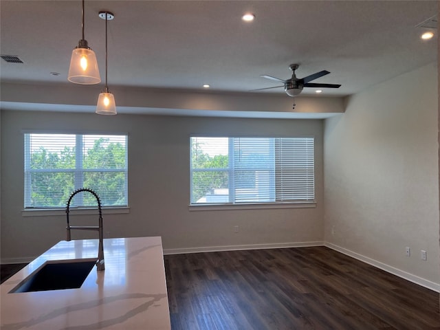 12001 Vista Parke Dr Unit 1202, Austin, TX 78726 - kitchen with light stone counters, recessed lighting, dark wood-type flooring, a ceiling fan, and pendant lighting