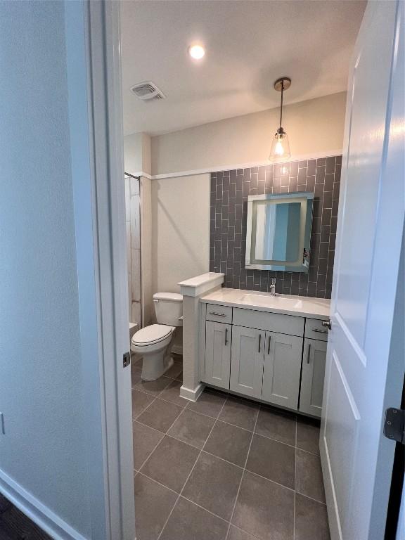 full bathroom with toilet, shower / bathtub combination, vanity, tile patterned flooring, and decorative backsplash