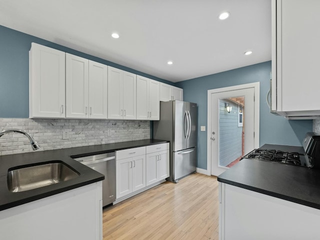 kitchen with tasteful backsplash, white cabinetry, sink, and stainless steel appliances