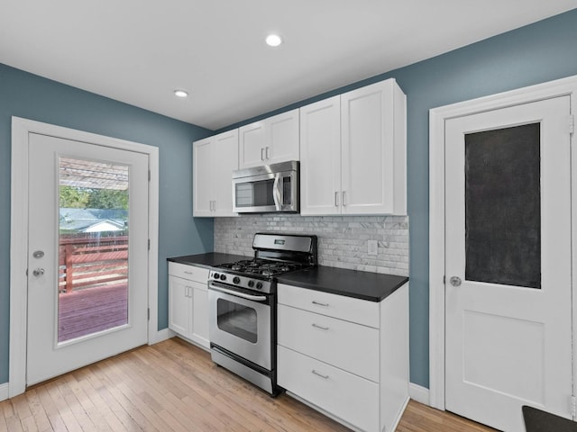 kitchen featuring decorative backsplash, light hardwood / wood-style floors, white cabinetry, and stainless steel appliances