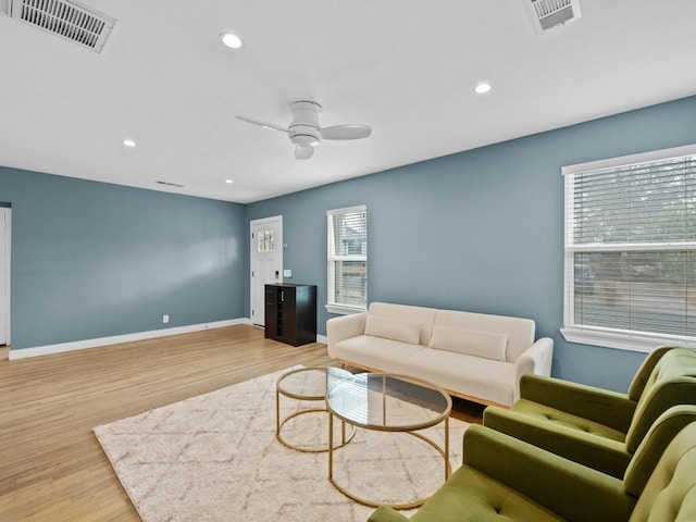 living room featuring light hardwood / wood-style floors, a wealth of natural light, and ceiling fan