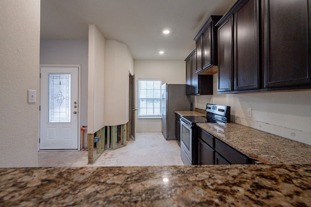 kitchen featuring appliances with stainless steel finishes, dark stone countertops, and dark brown cabinets