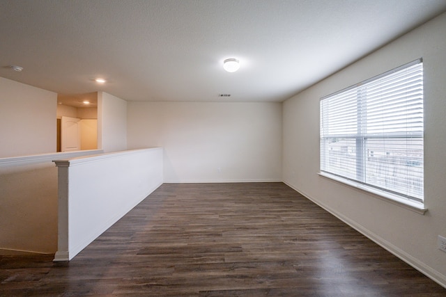 empty room with dark hardwood / wood-style flooring