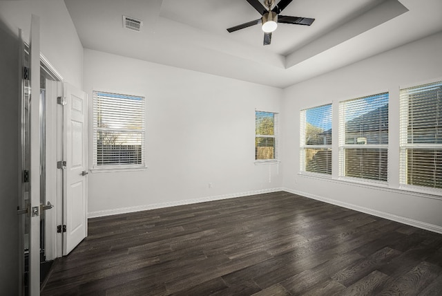 unfurnished room with dark hardwood / wood-style floors, ceiling fan, and a tray ceiling