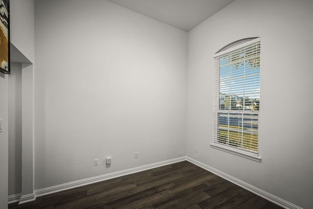 unfurnished room with dark wood-type flooring