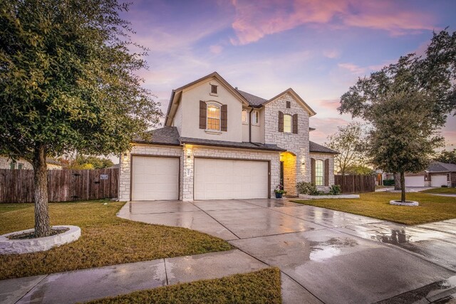 front of property with a garage and a lawn