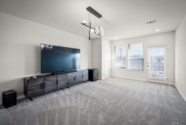 unfurnished living room with light carpet and a chandelier