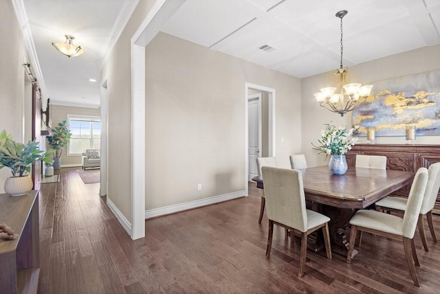 dining area with dark hardwood / wood-style floors, crown molding, and an inviting chandelier