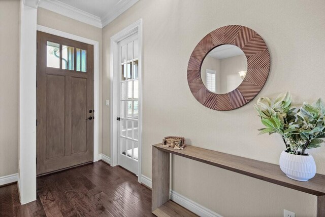 foyer entrance with dark hardwood / wood-style flooring and ornamental molding