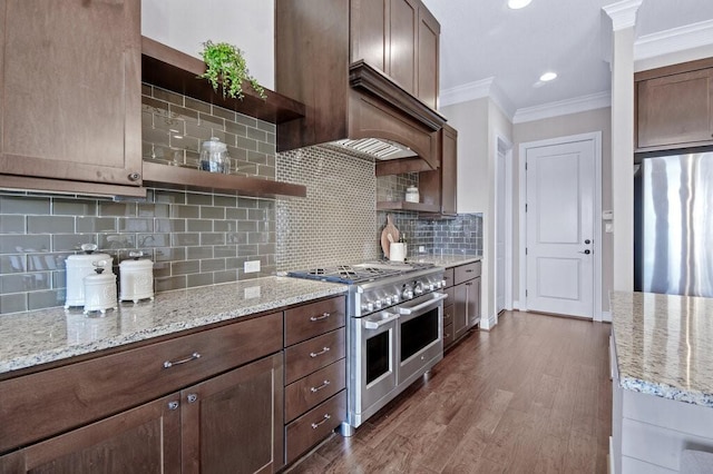 kitchen with tasteful backsplash, dark brown cabinetry, light stone countertops, and stainless steel appliances