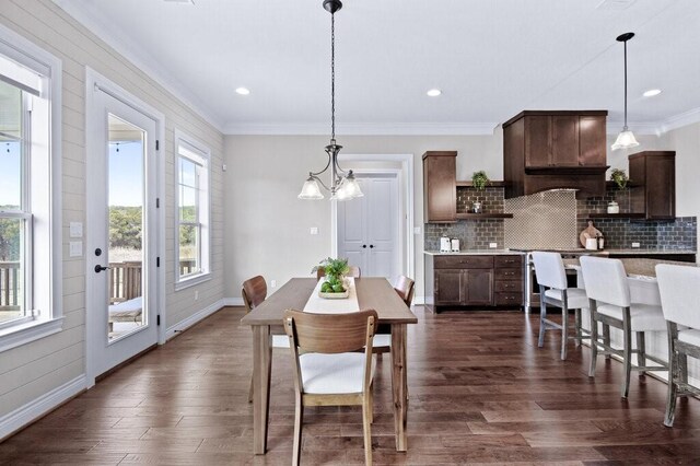 dining space featuring a notable chandelier, dark hardwood / wood-style flooring, and crown molding